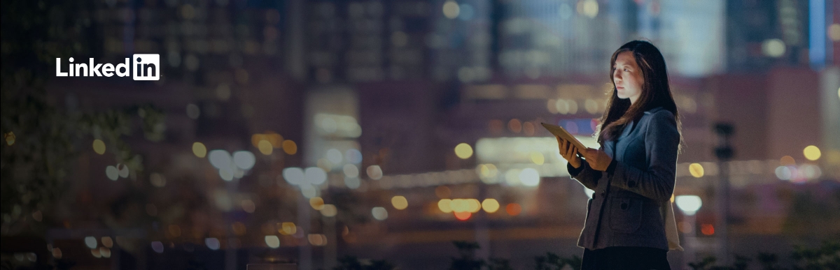 Woman standing on roof of city building holding a tablet