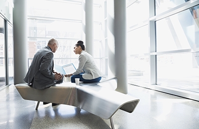 Two people sitting at bench in discussion