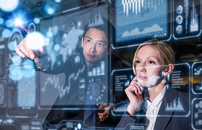 Two people working on a clear computer screen
