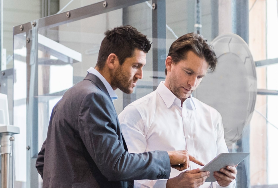 Two men looking at a tablet