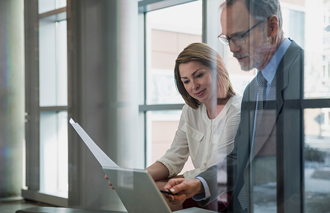 Man and woman looking at data on laptop