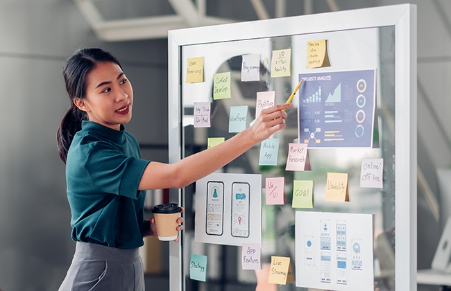 Woman presenting using a glass board