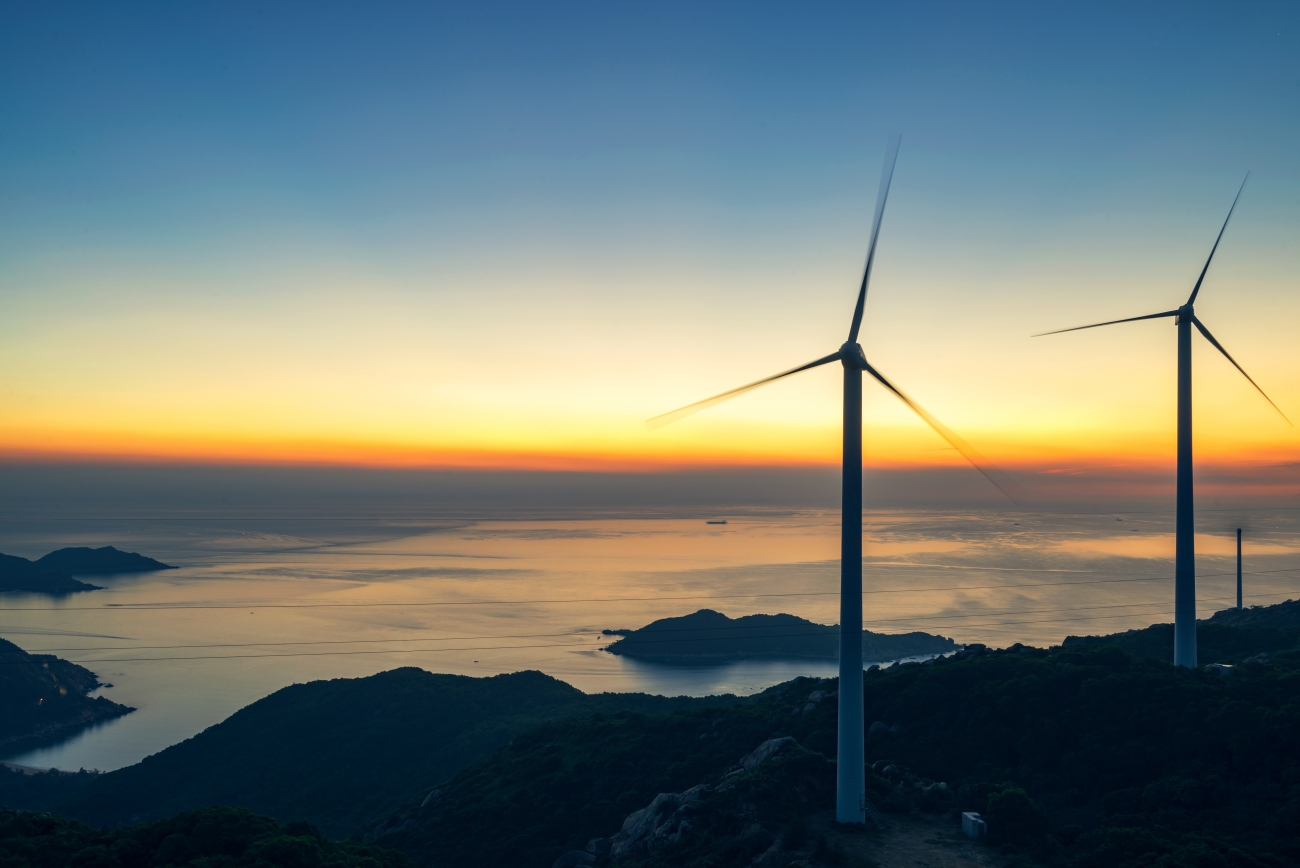 Windmills with a sunrise behind them