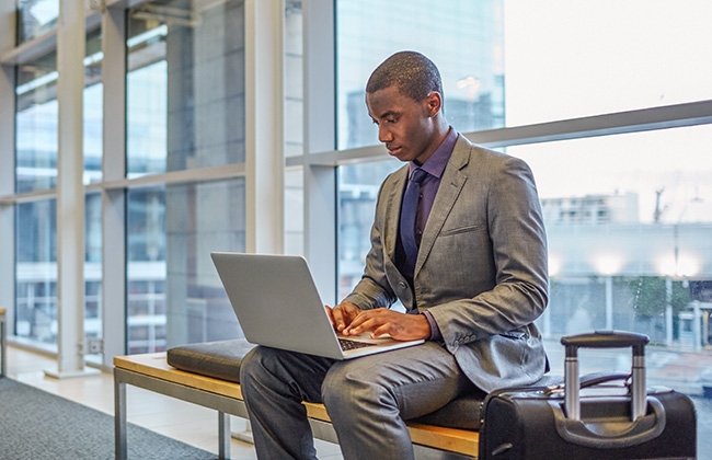 Man at airport working on laptop