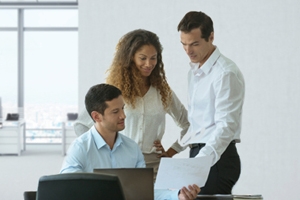 Image of coworkers looking at a document together. 