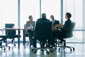 Image of coworkers meeting in a conference room. 