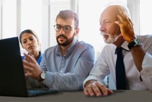 Three people looking at a computer