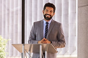 Image of a business man speaking at a podium. 