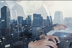 Reflection of people working in a window overlooking a city.