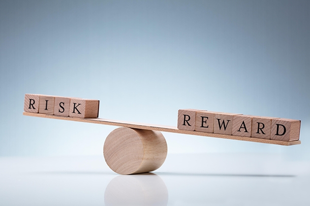 The words Risk and Reward on opposite sides of a balance board