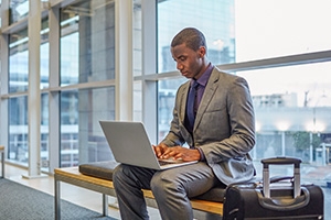 Man at airport working on laptop